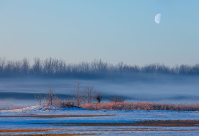 Snowy sunrise with the moon over Ohio landscape